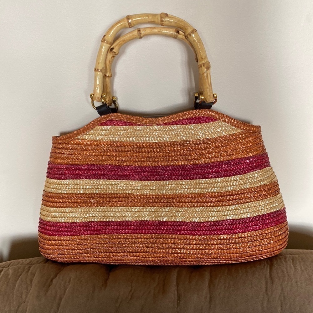 Gorgeous straw purse w/ bamboo handles. Snap closure and several inner pockets